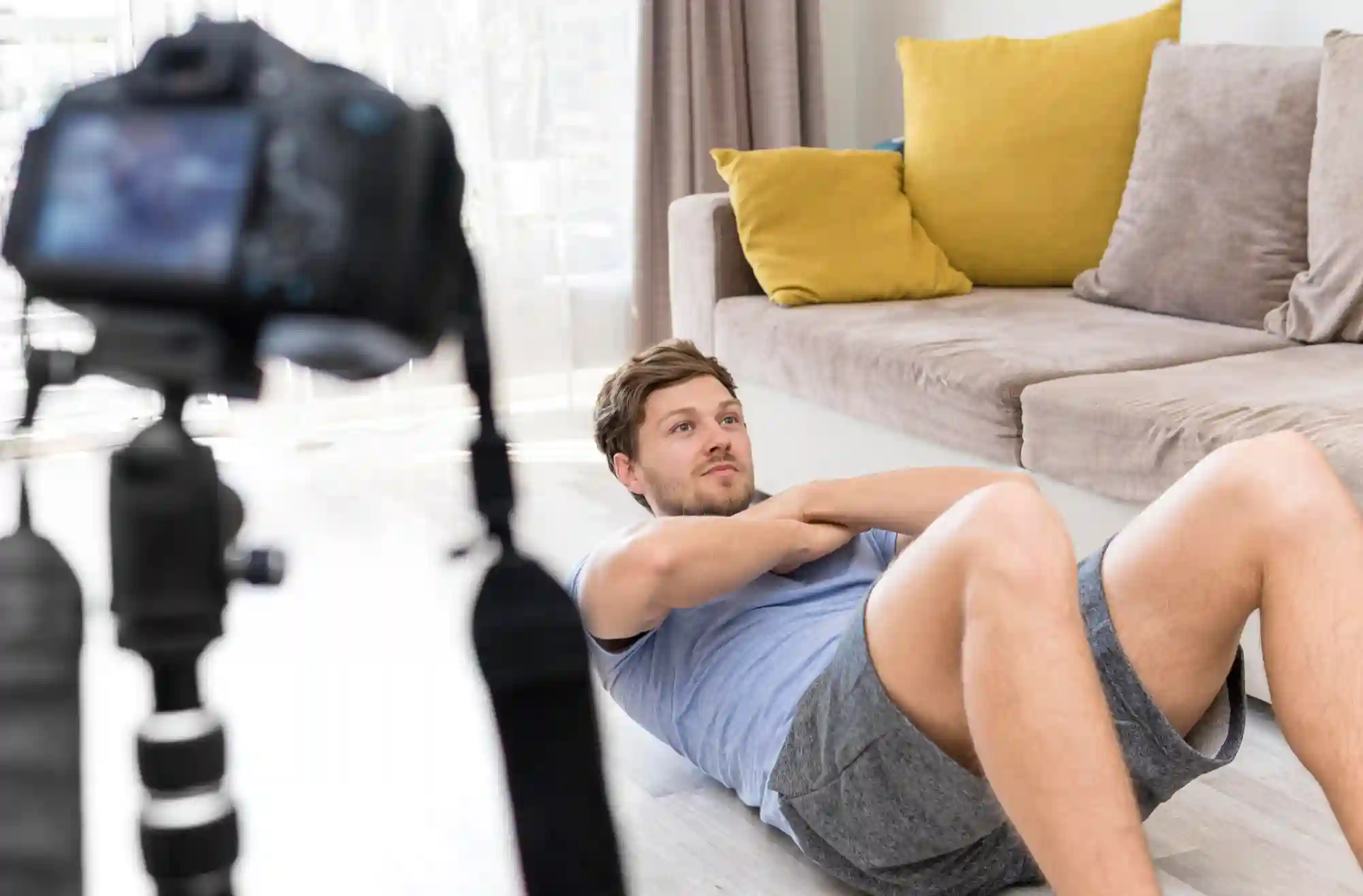 A man films himself doing crunches for a video.