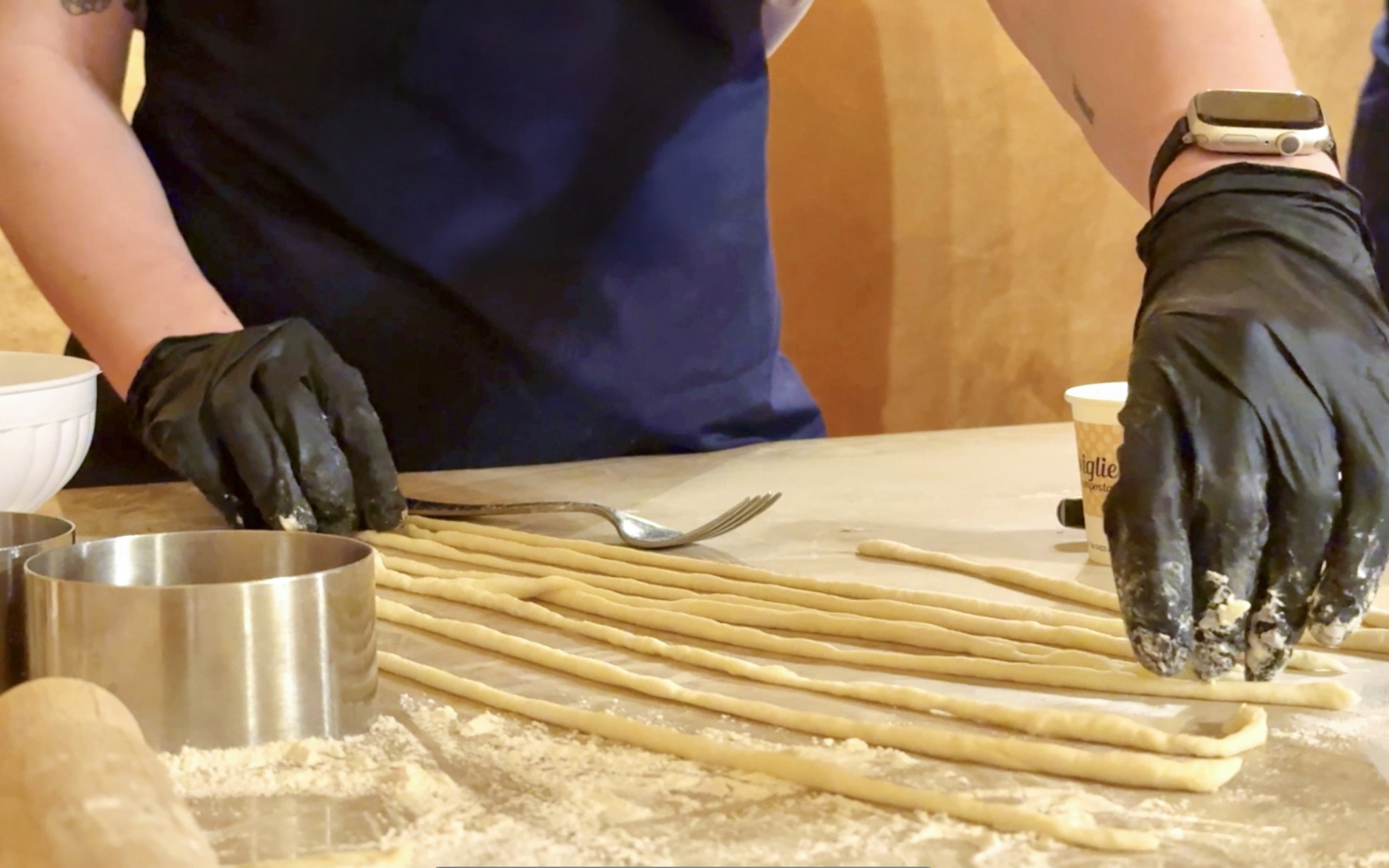 Participant preparing pasta during cooking class in Siena.