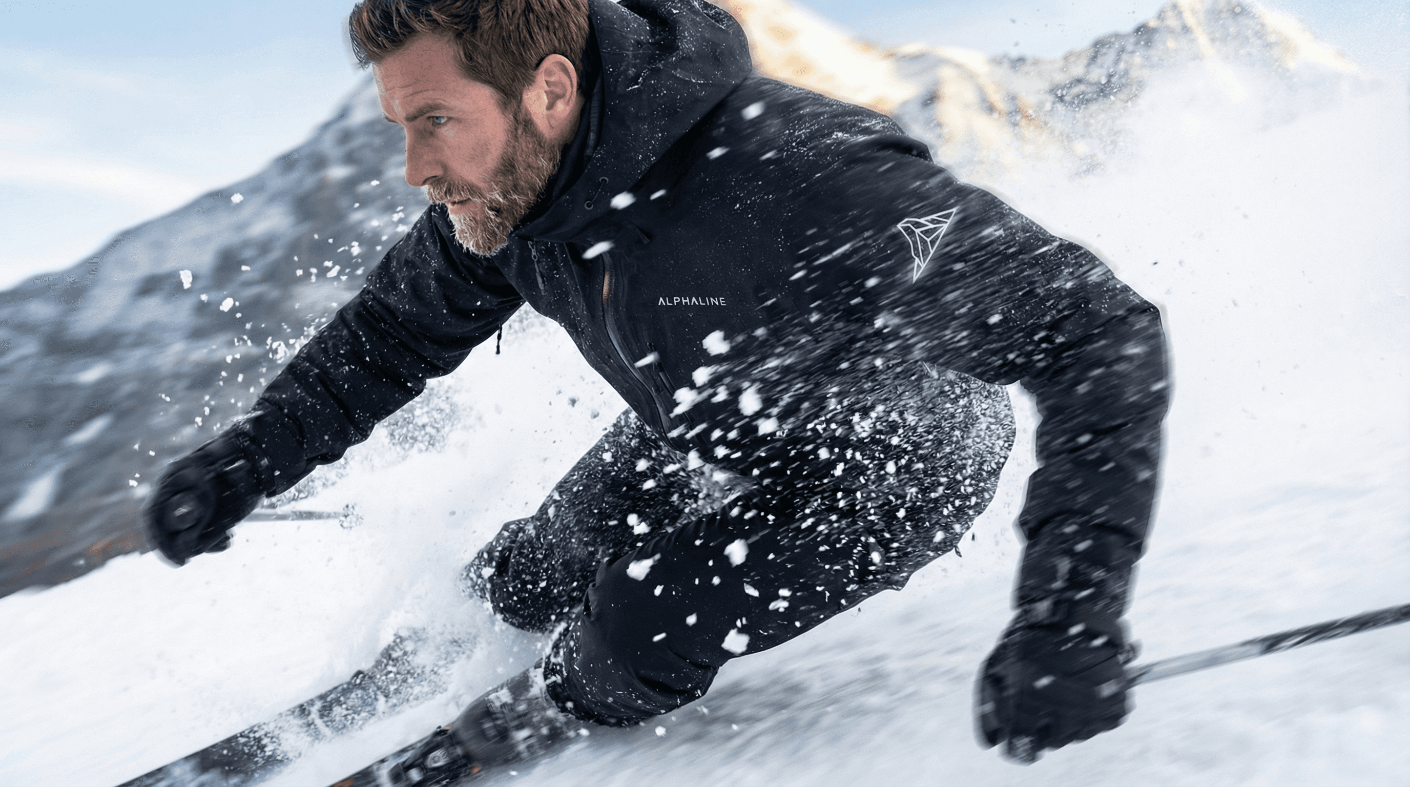 Man wearing ALPHALINE outerwear while skiing through snow