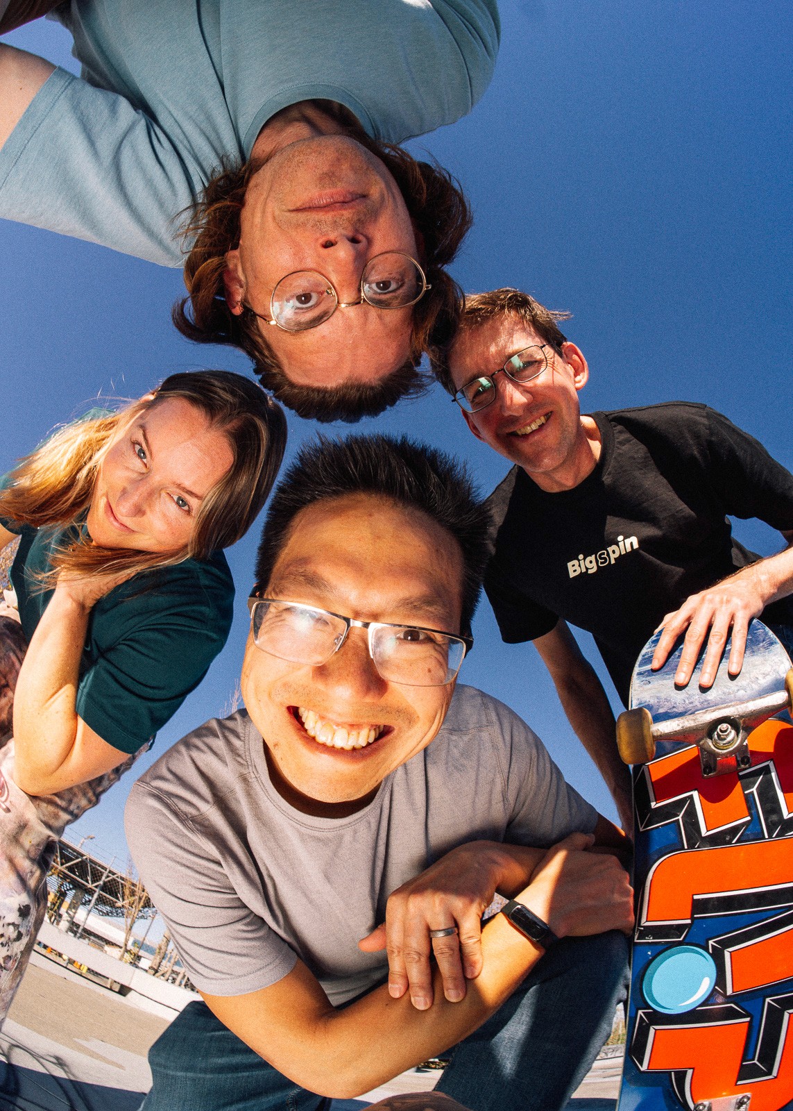 Chris, co-founder, holding a skateboard over his head outdoors