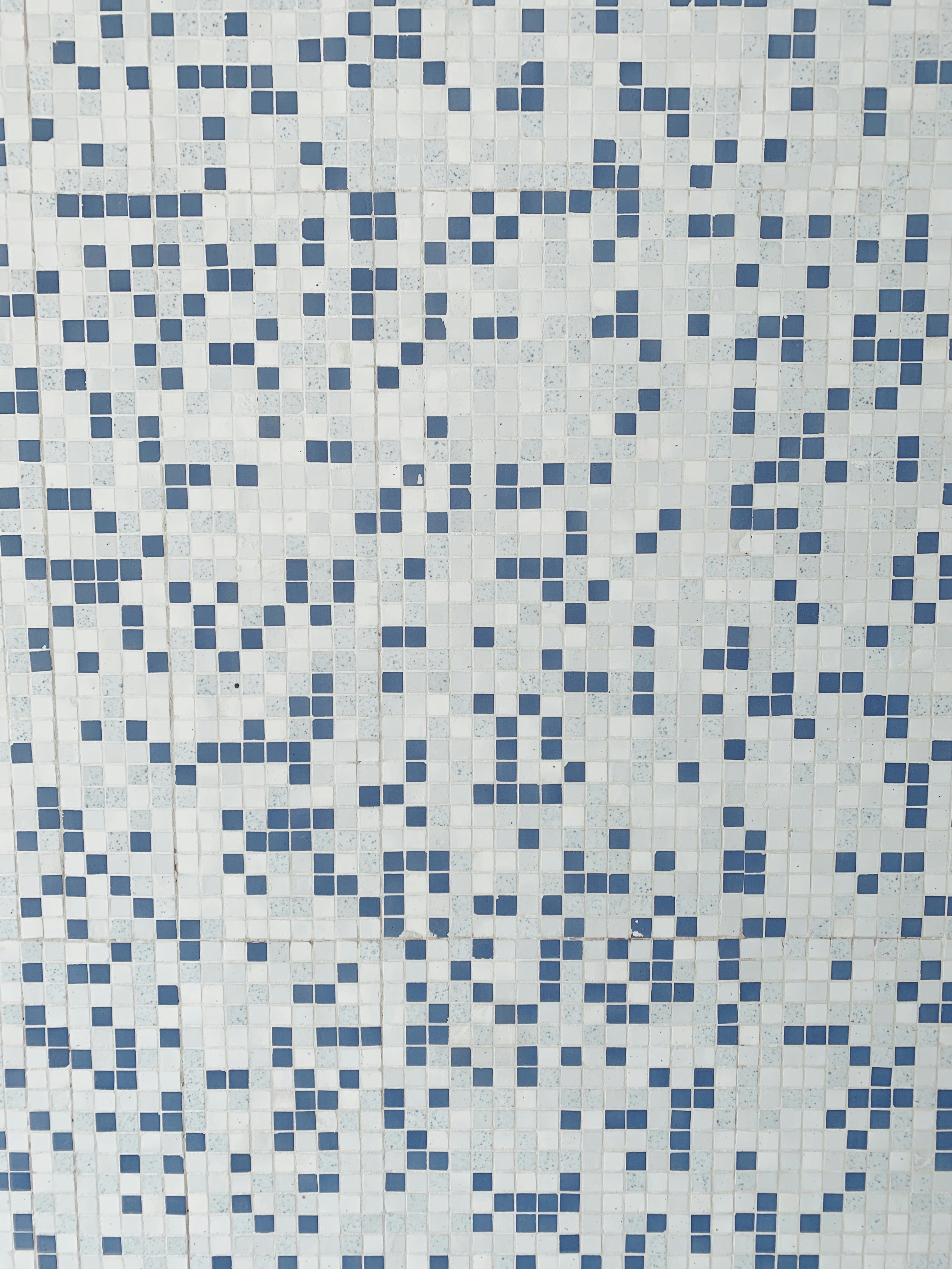 a white and blue tiled wall with blue squares