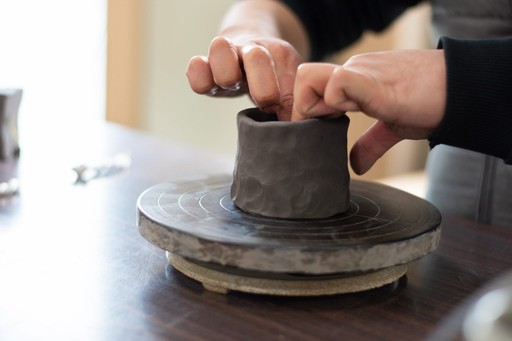 Hand crafting a personal piece of Bizen pottery on a small pottery wheel