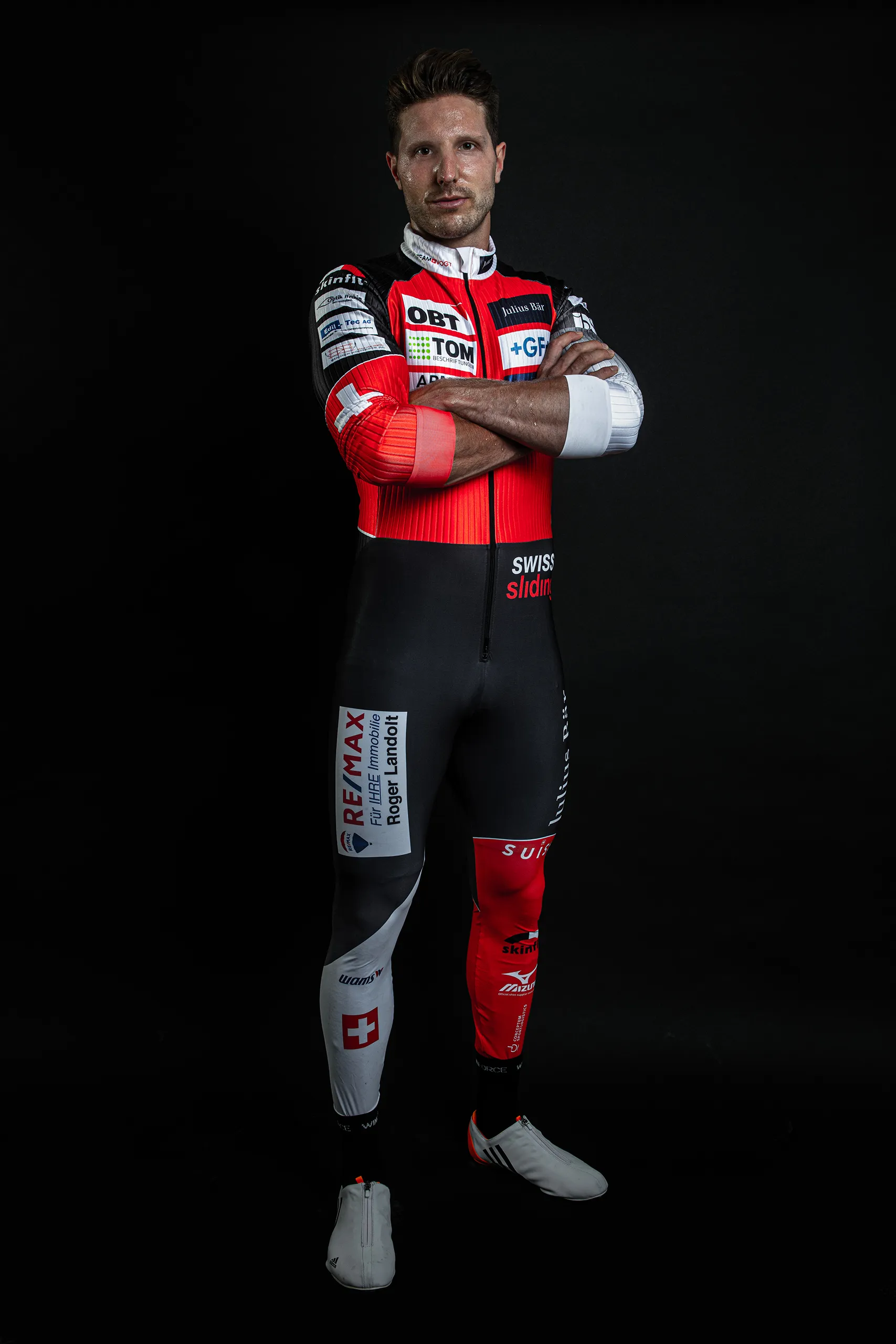 Bobteam Vogt athlete in racing suit against a pure black studio background