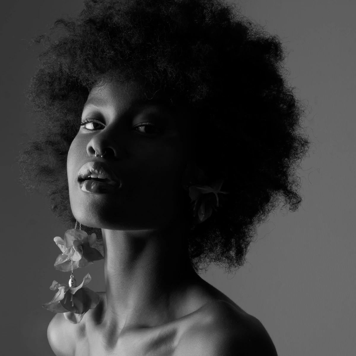 Portrait noir et blanc mode éditorial, mannequin afro, jeu d'ombres et lumière artistique