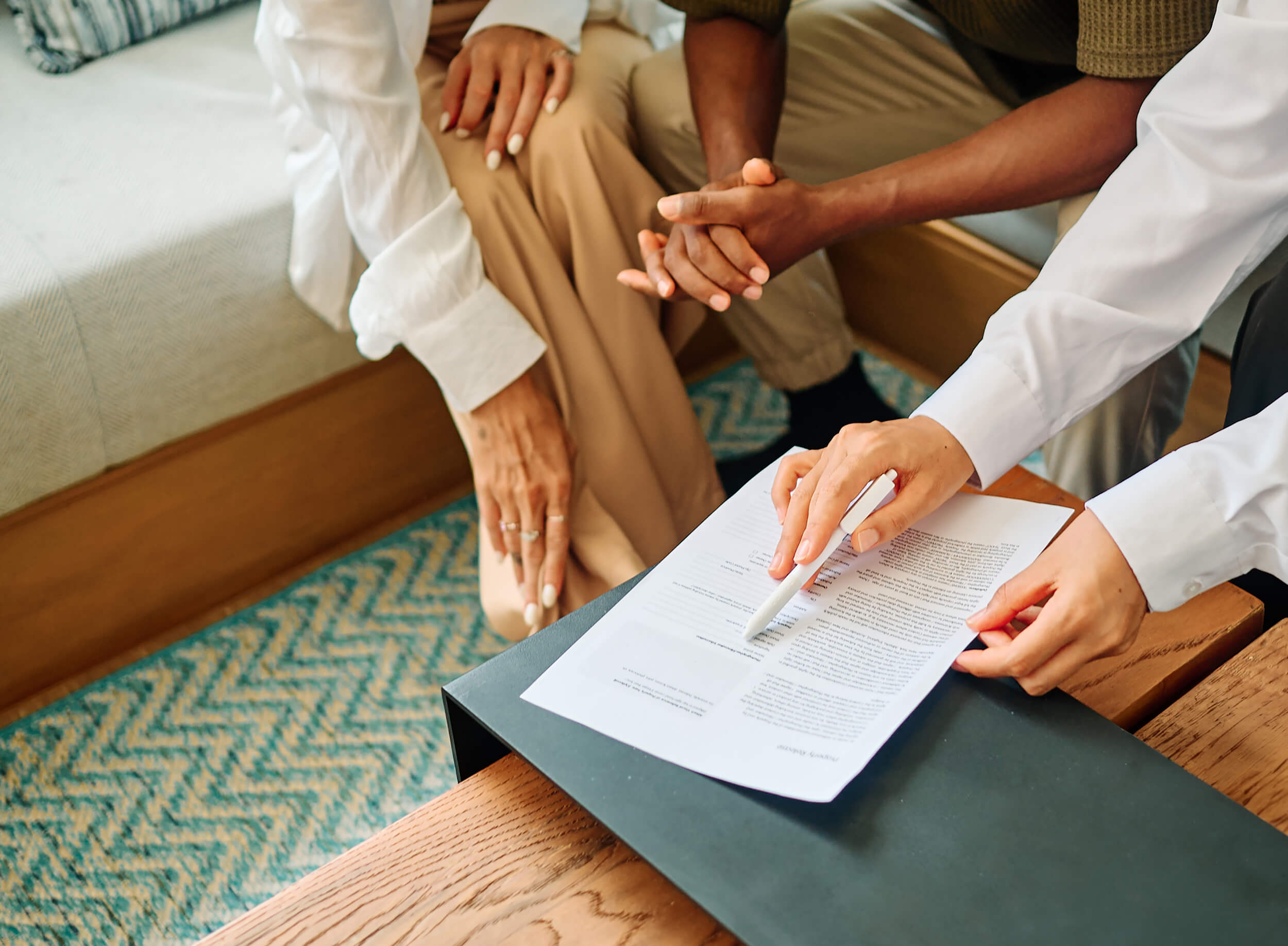 Close up of a group of people pointing at a piece of paper