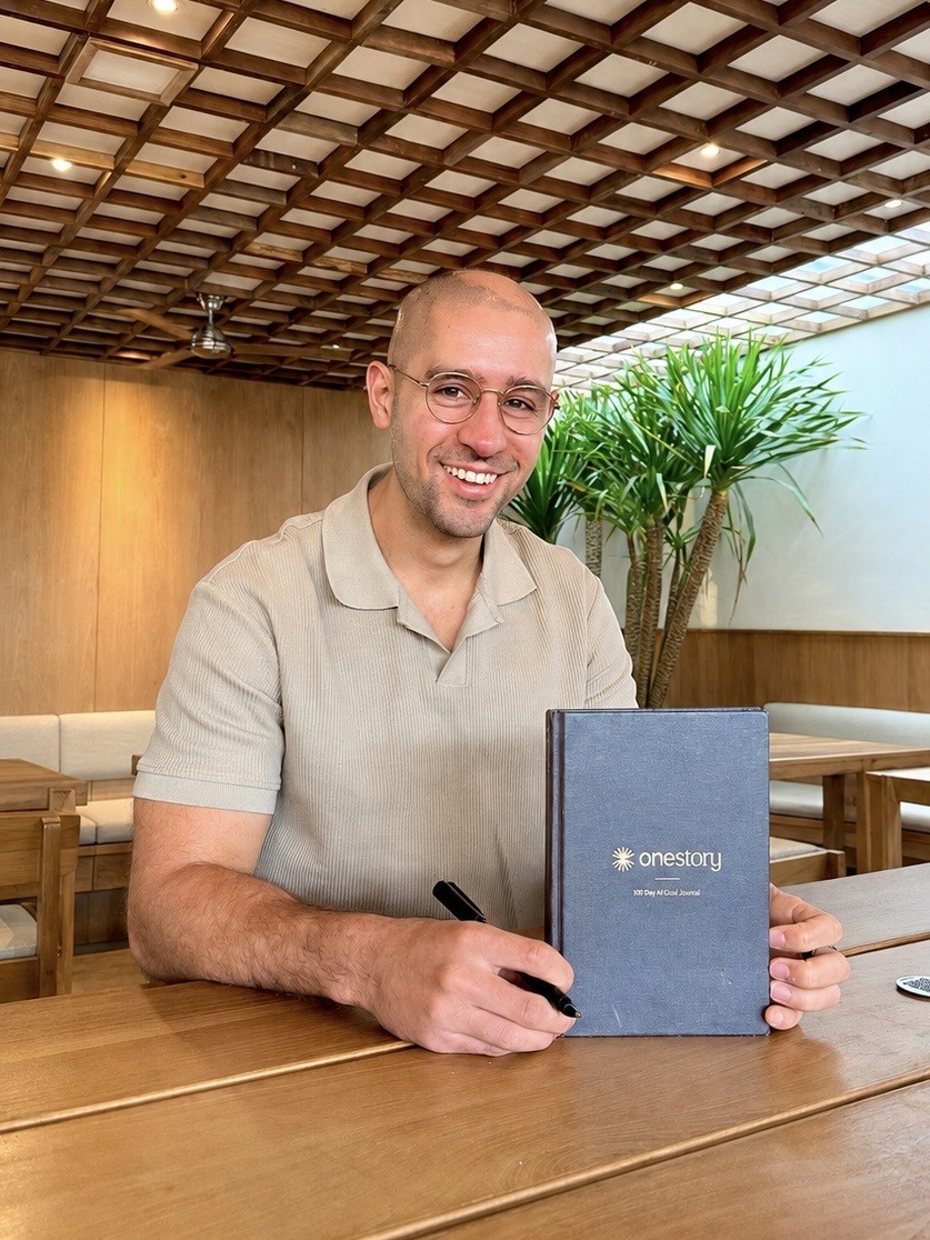 Logan Sneed holding the One Story journal and smart pen