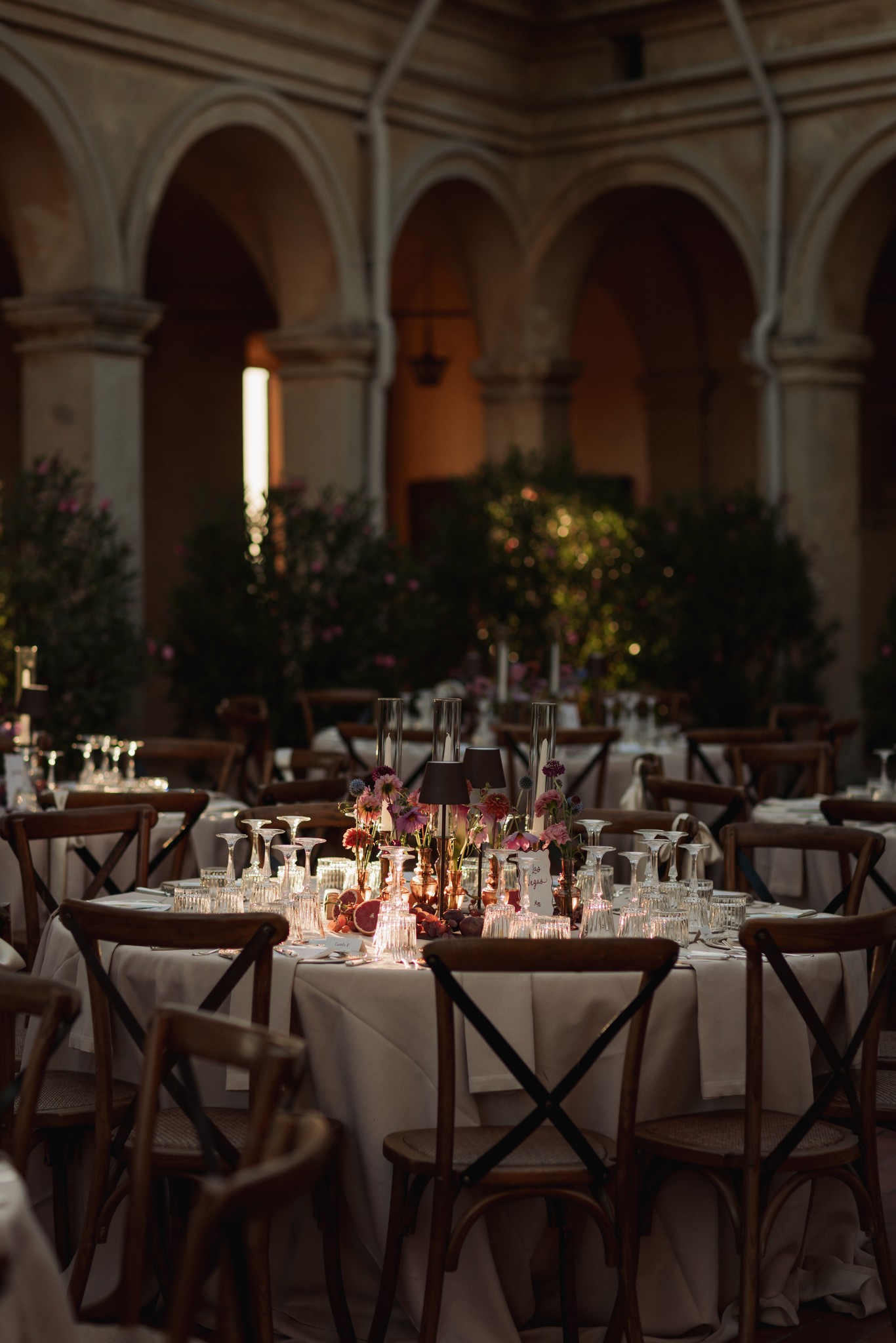 Ricevimento di matrimonio al Castello di Scipione, tavoli in sala con arcate medievali e luce dorata dalle finestre