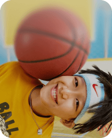 Small boy playing basketball and smiling