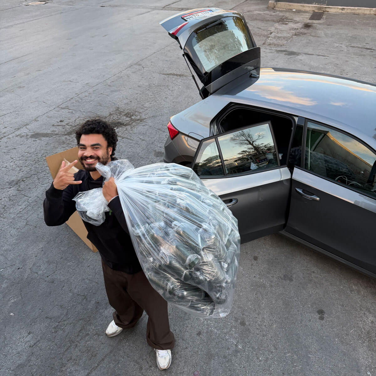 Oily founder holding bag of new bottles to be processed