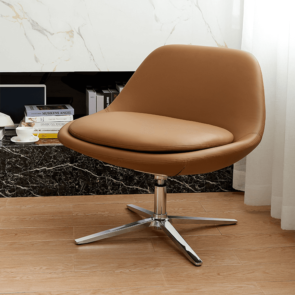 Modern tan leather swivel lounge chair with chrome base in contemporary living room – curved egg-shaped accent armchair on marble floor with books and decor