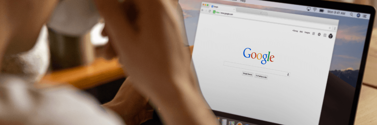Roboterhand tippt auf einem Laptop, umgeben von holografischen KI-Symbolen