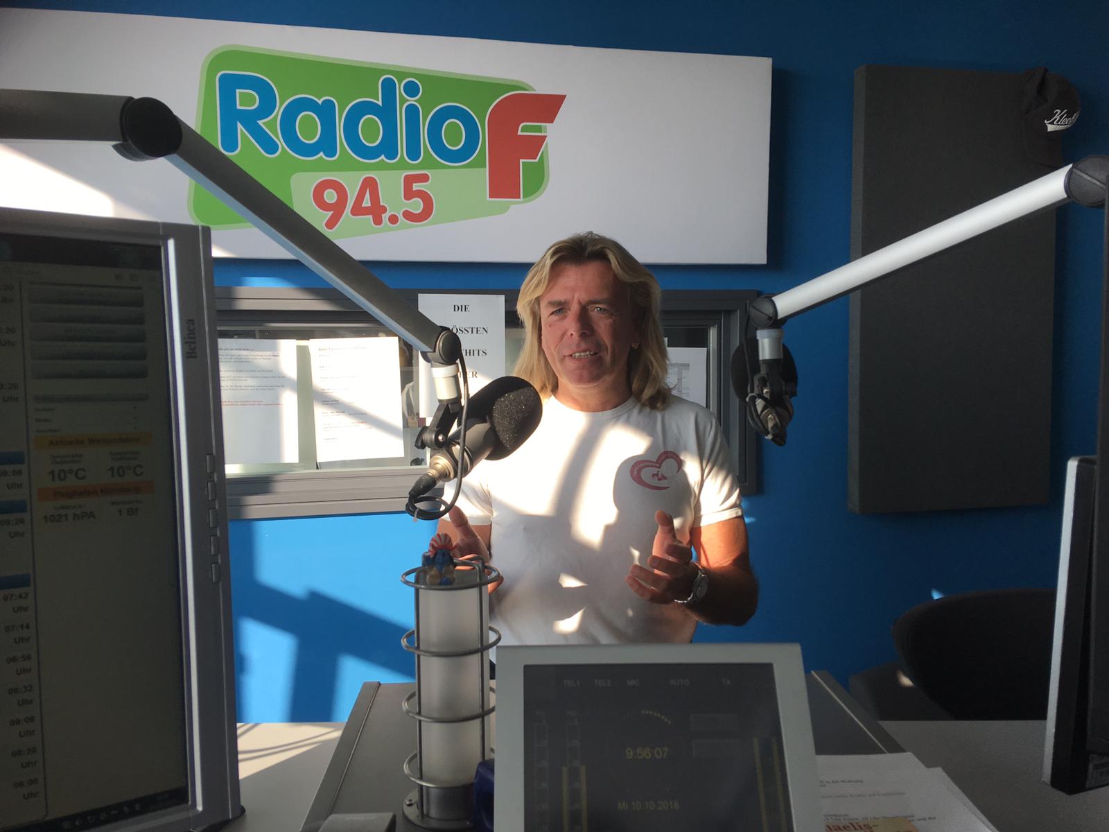 Frontaufnahme: Marcel Combé spricht im Radiostudio in ein Mikrofon.