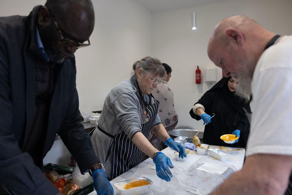 group of women in red and white dress standing on brown wooden bar during daytime