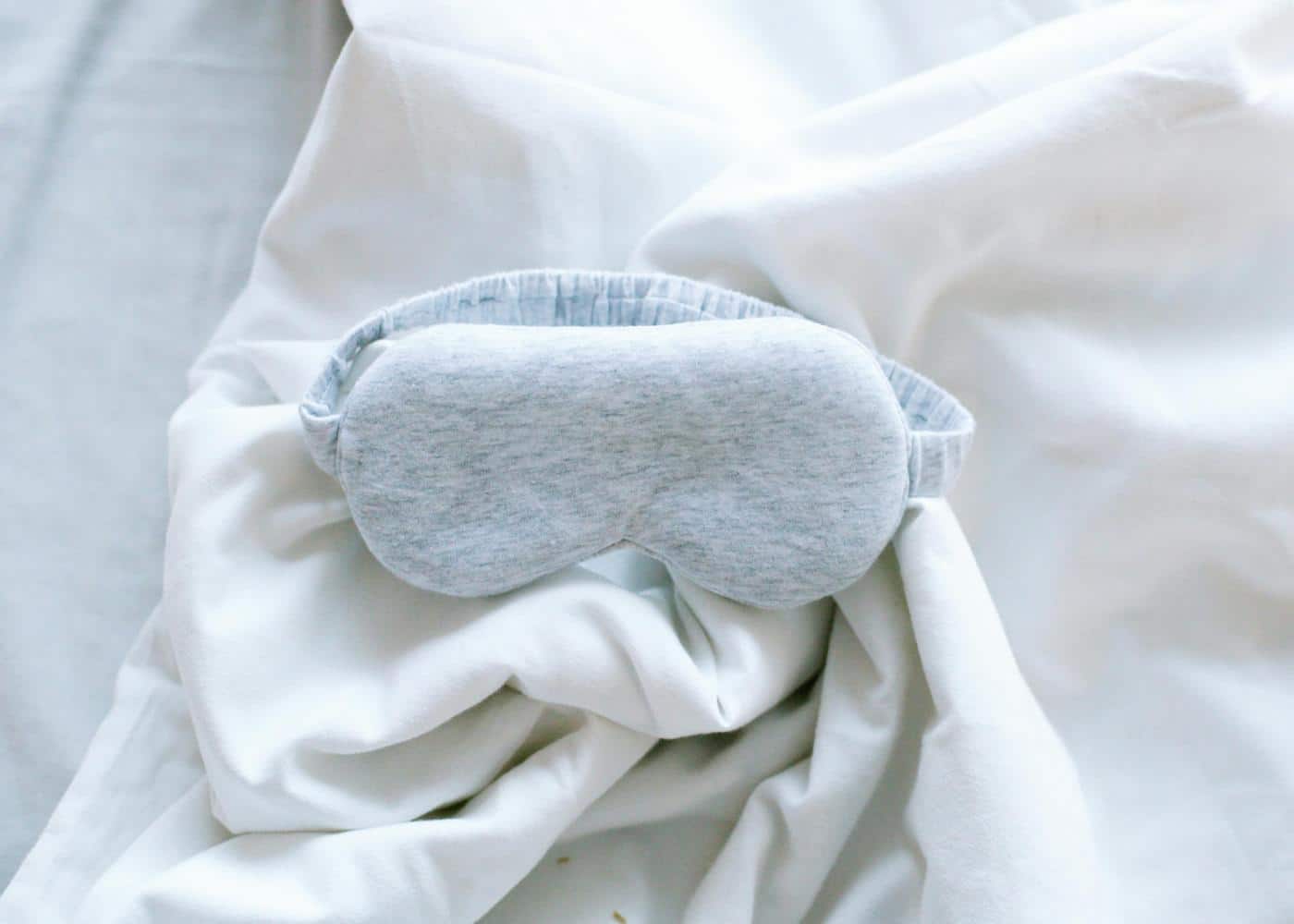 Picture of an eye massager sitting on white sheets