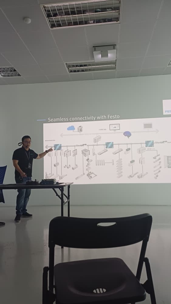 Festo expert guiding Autofill engineers through a practical PLC and pneumatic system setup on the knowledge bench.