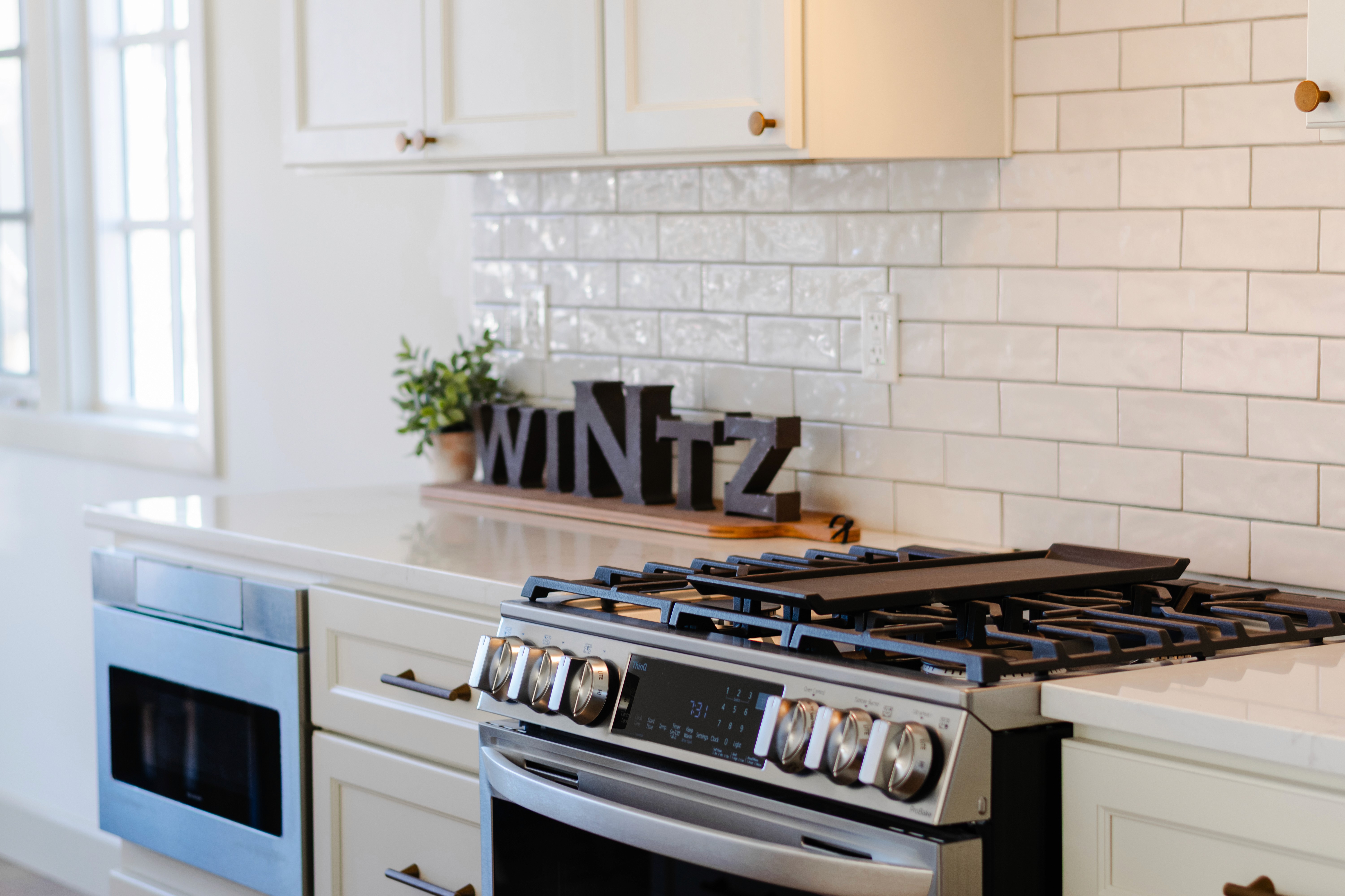 Stainless steel, gas stove and microwave mounted under the counter.
