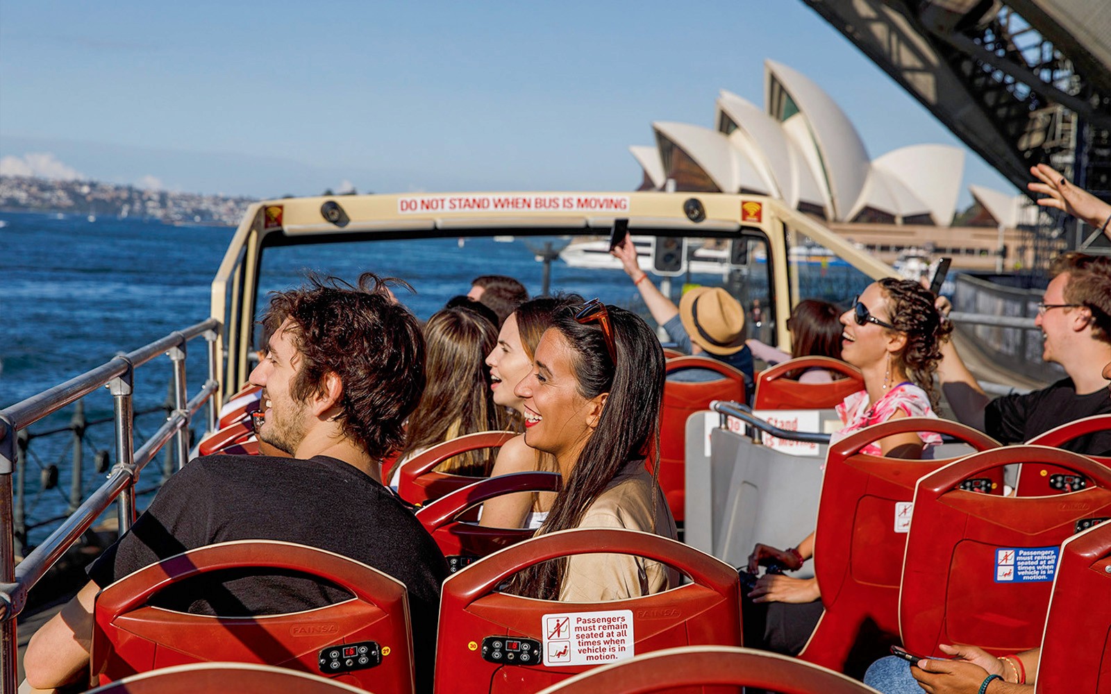 Passengers on Big Bus Sydney near Sydney Opera House enjoying the view.
