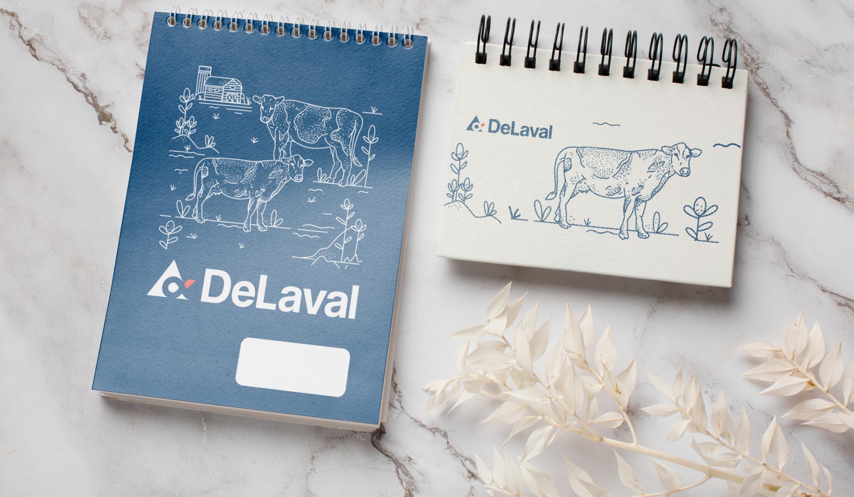 Zestaw gadżetów firmowych: projekt notesu spiralowanego ze szkicami odręcznymi.