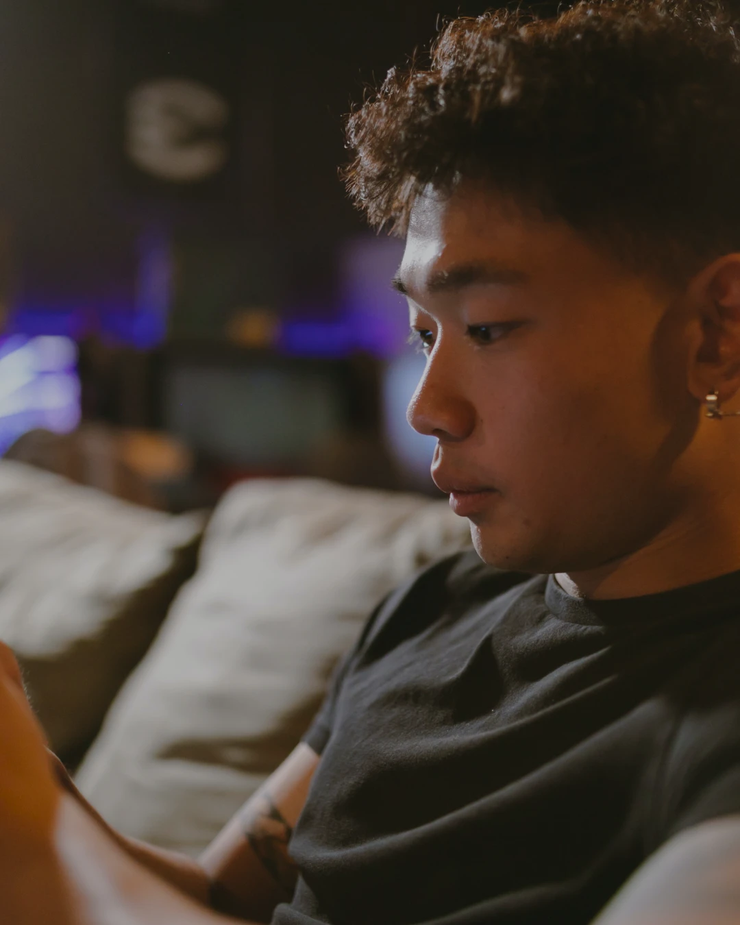 A young man looks pensive as he stares down, presumably into a phone