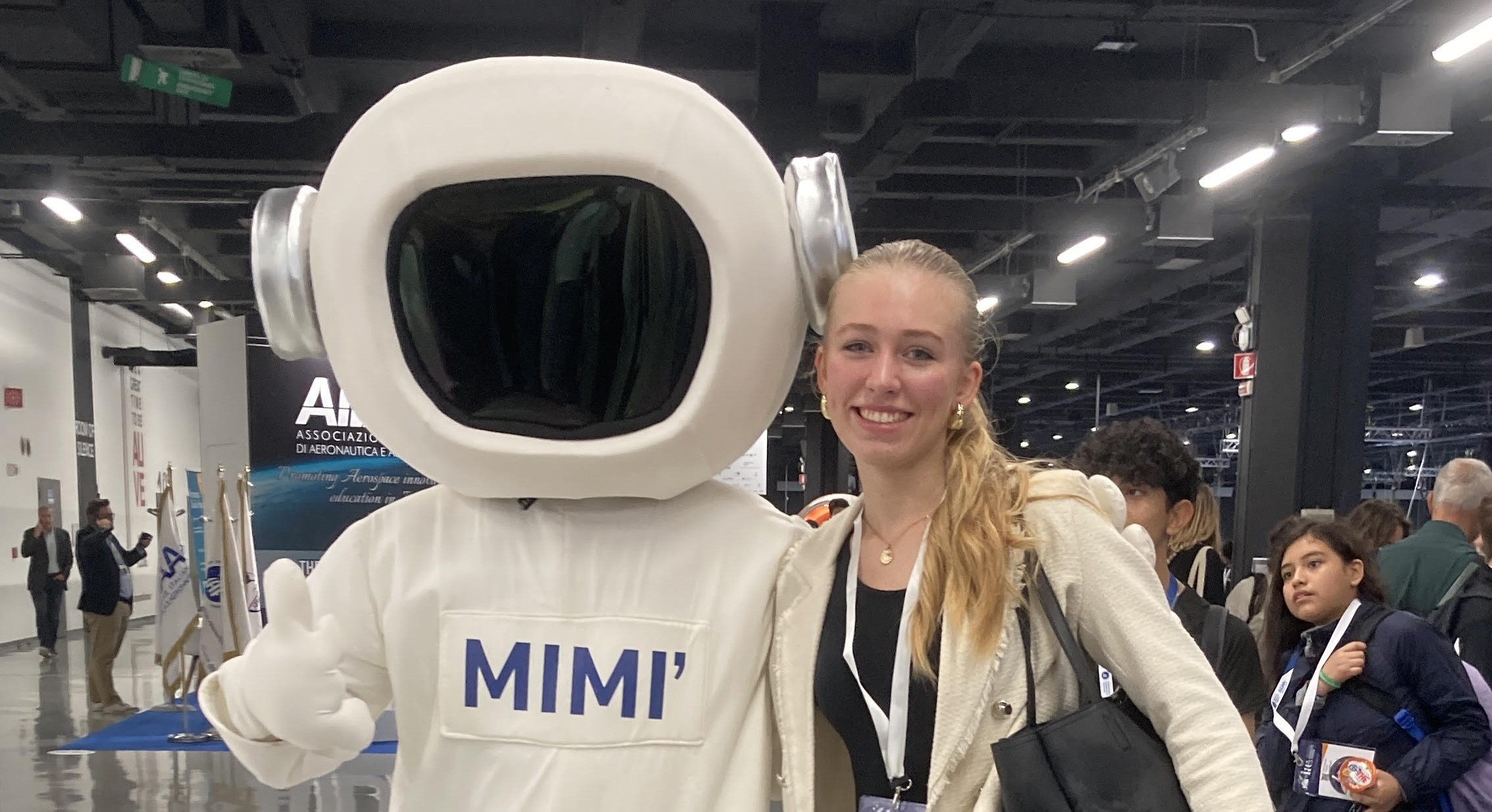 Elisa with an astronaut mascot at a conference