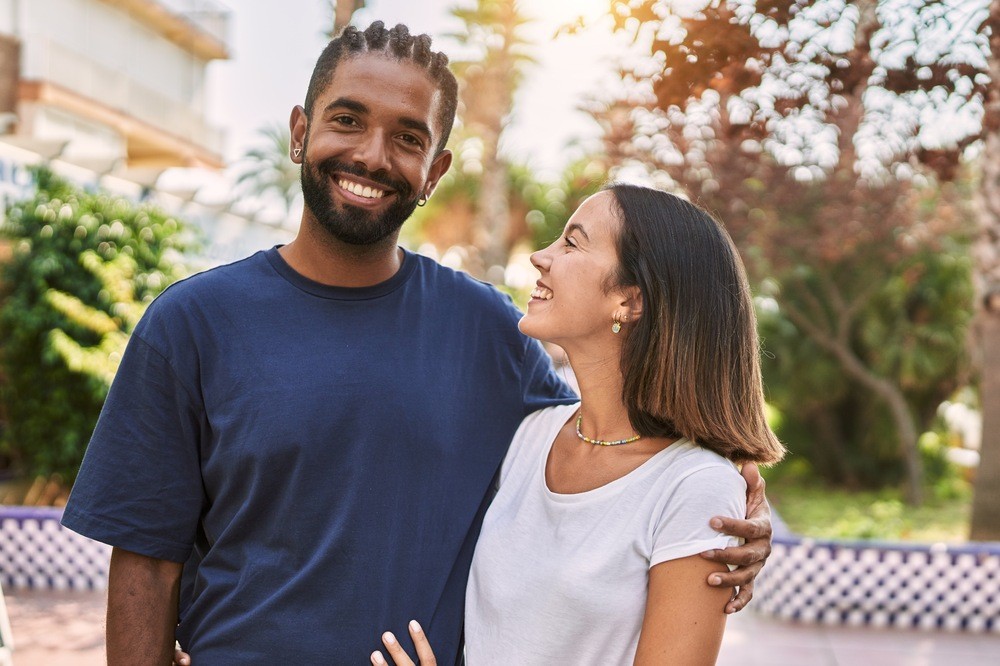 Couple souriant dans un parc, représentant la sécurité financière à long terme offerte par l'assurance-vie entière.