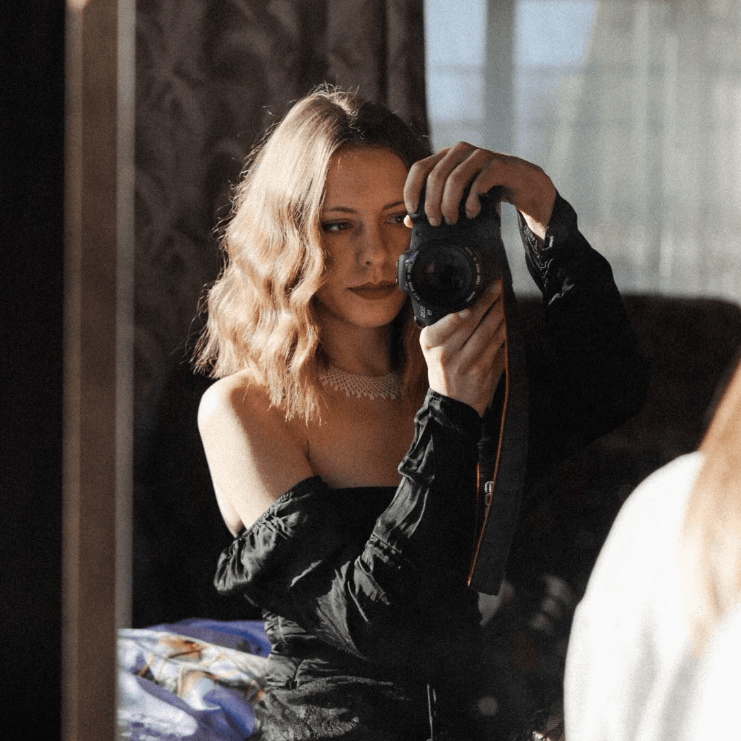 A woman in a straw hat stands in the grass