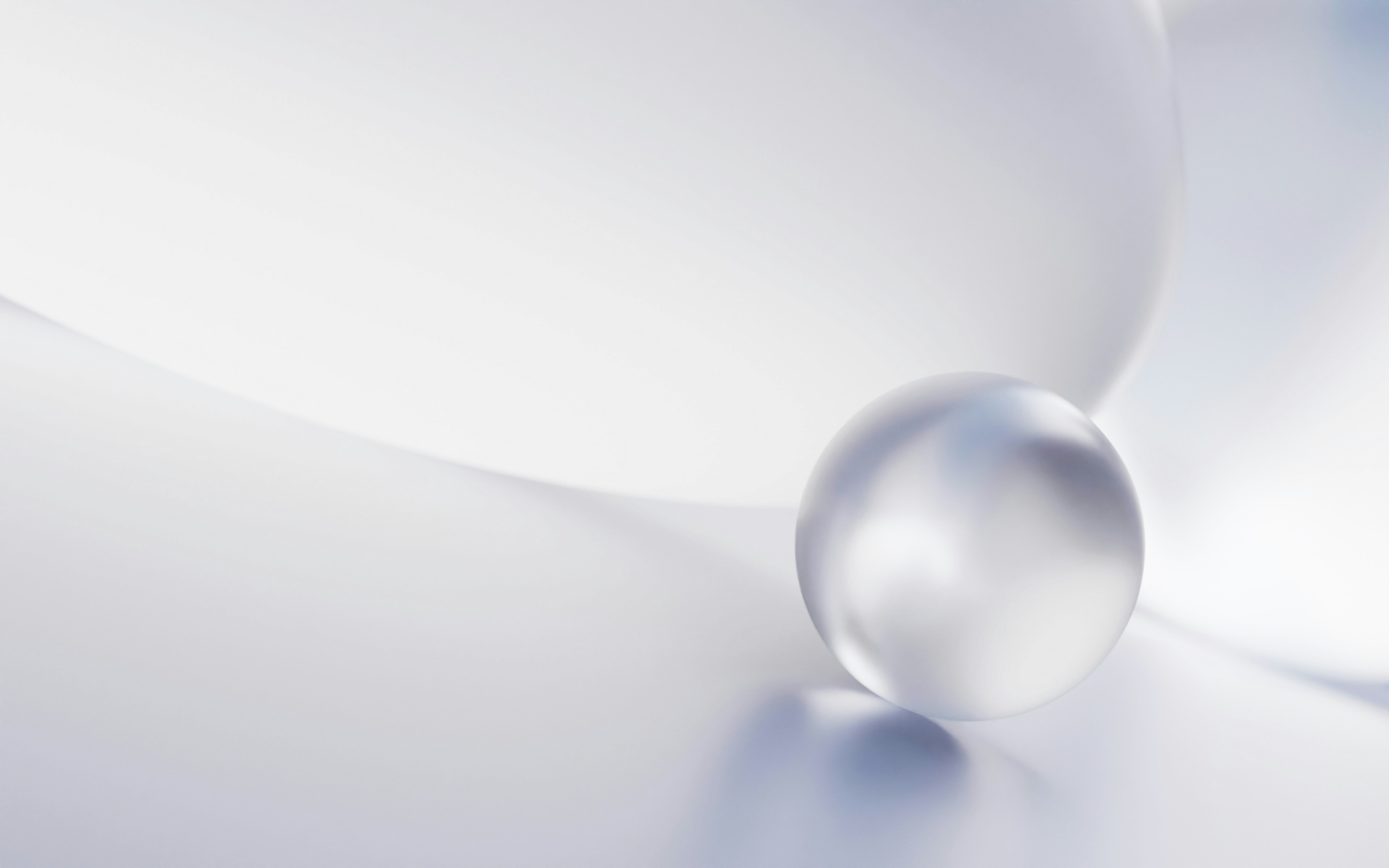 A crystal ball rests on a curved surface.