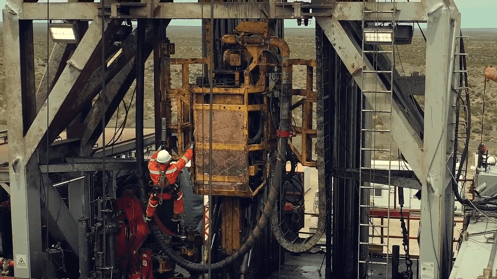 A photo of an oil production worker at work wearing a RealWear headset