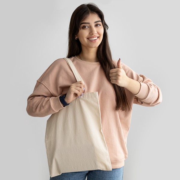 image of woman holding a recycled and reusable tote bag