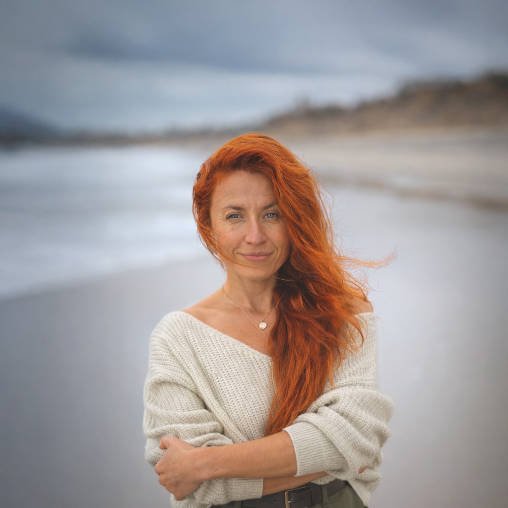 Ellen Manilova, San Diego family photographer, standing by the ocean.