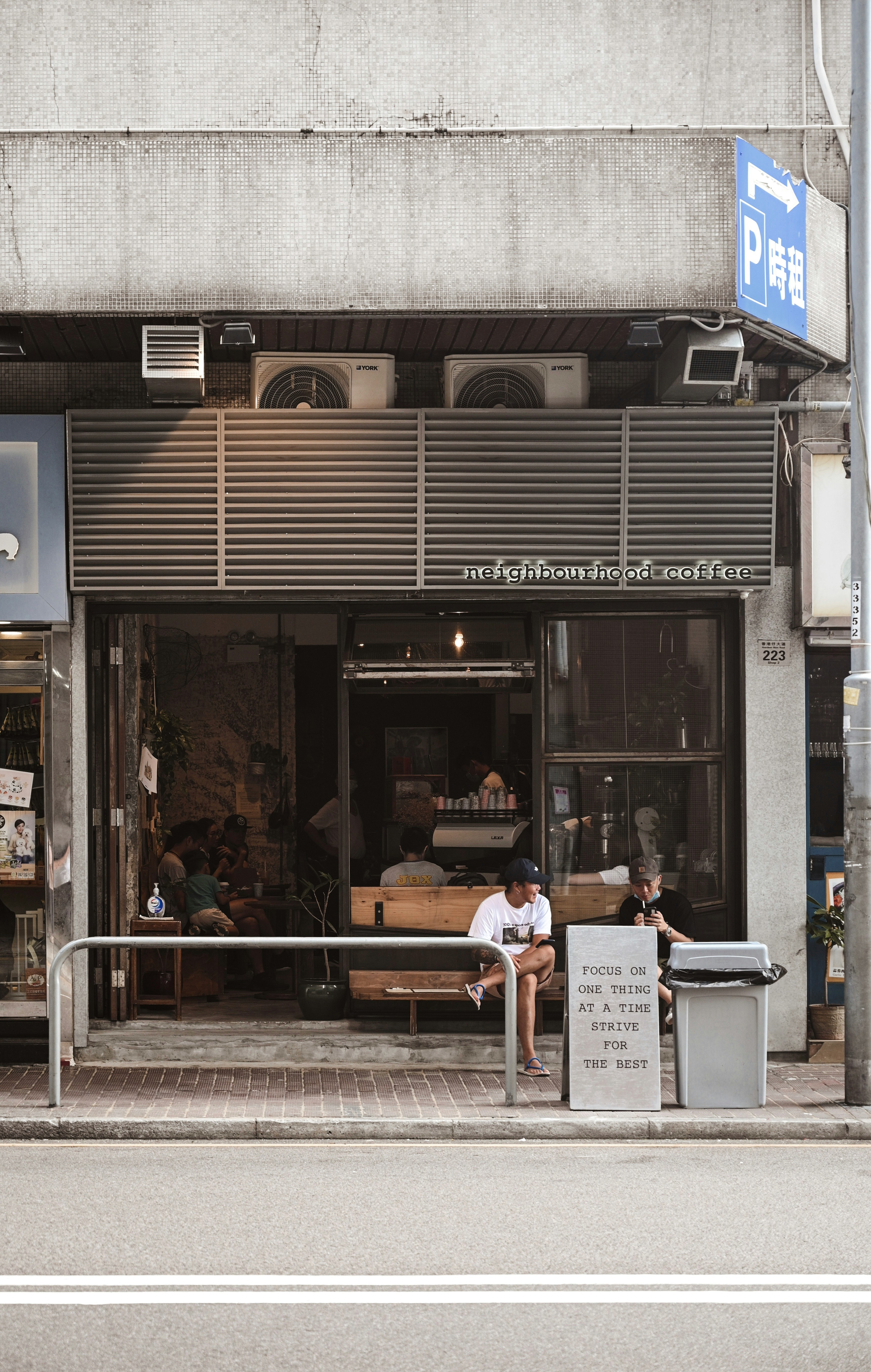 people sitting on bench in front of store during daytime