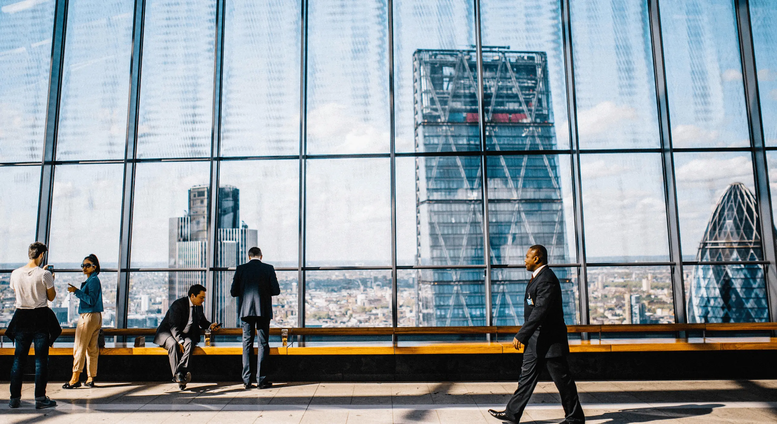People in a modern office with a London skyline view.