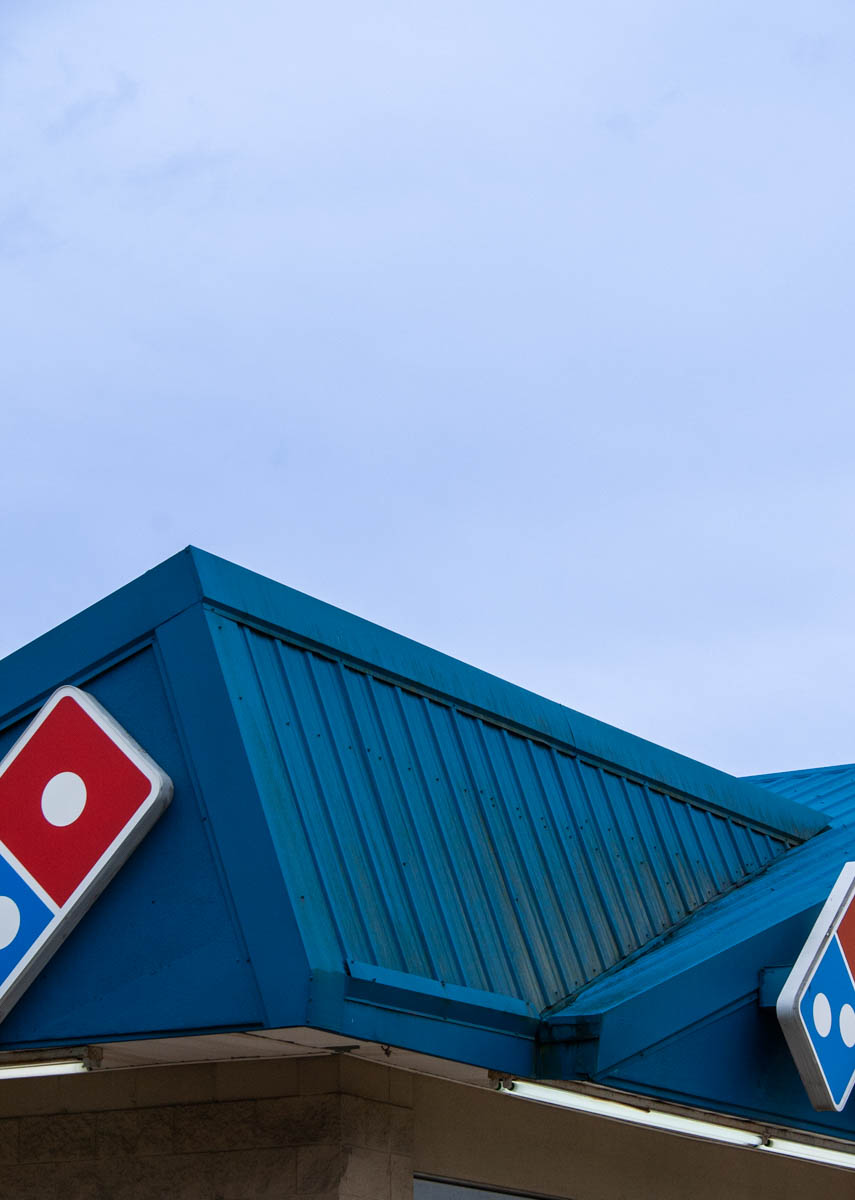 top corner of building with red and blue logo on the side