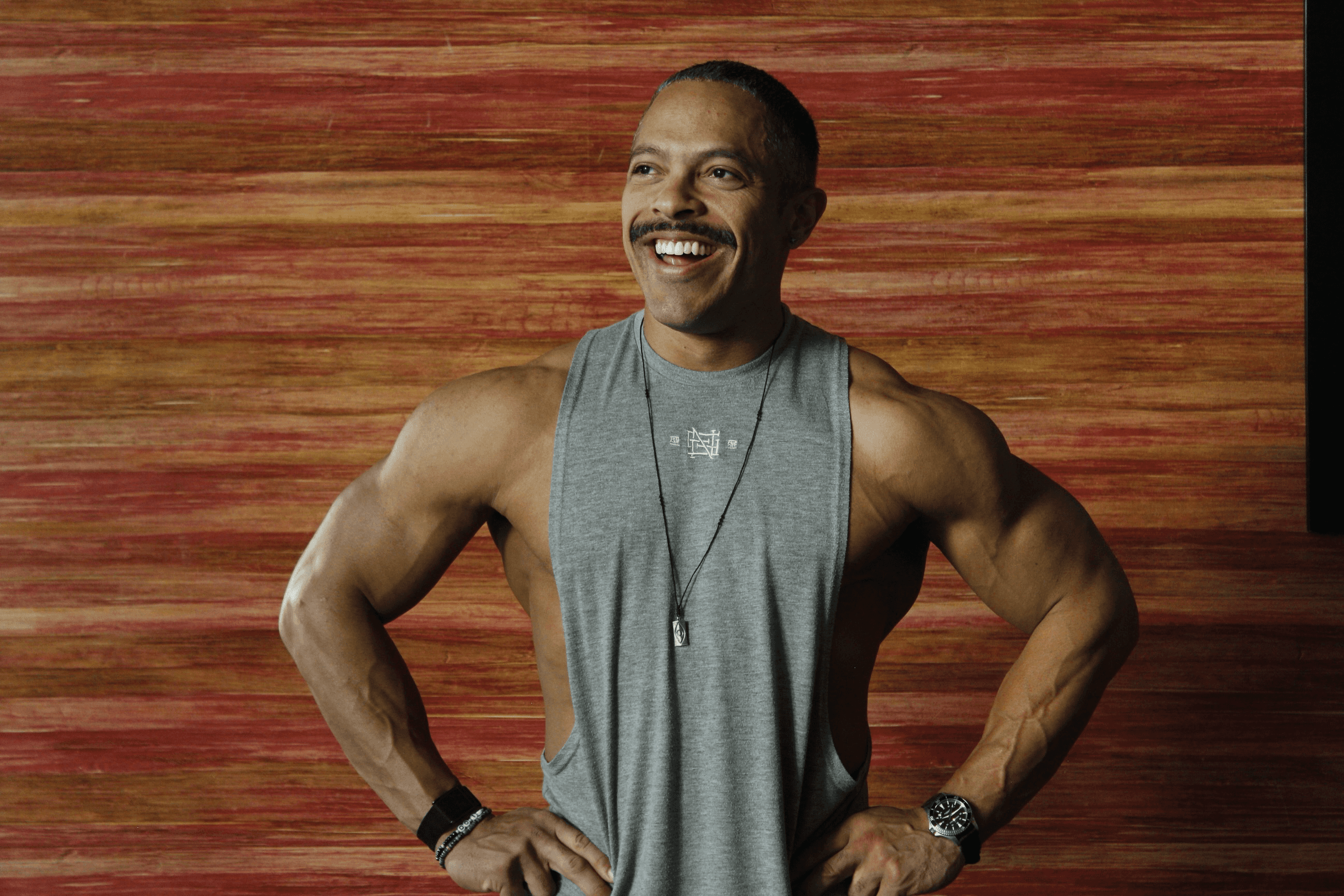 Two individuals are working out in a gym, focusing on dumbbells and strength training equipment.