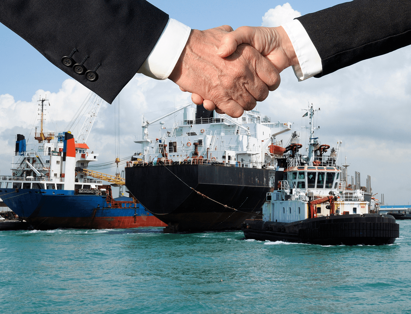 Two hands shaking in front of boats in a harbor, symbolizing partnership or agreement in maritime industry.