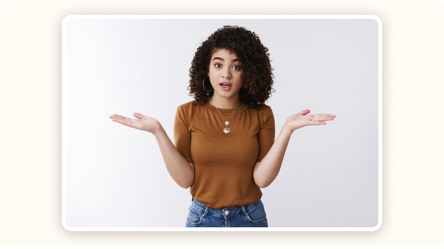 Jeune femme aux cheveux bouclés levant les deux mains avec un air surpris ou interrogatif
