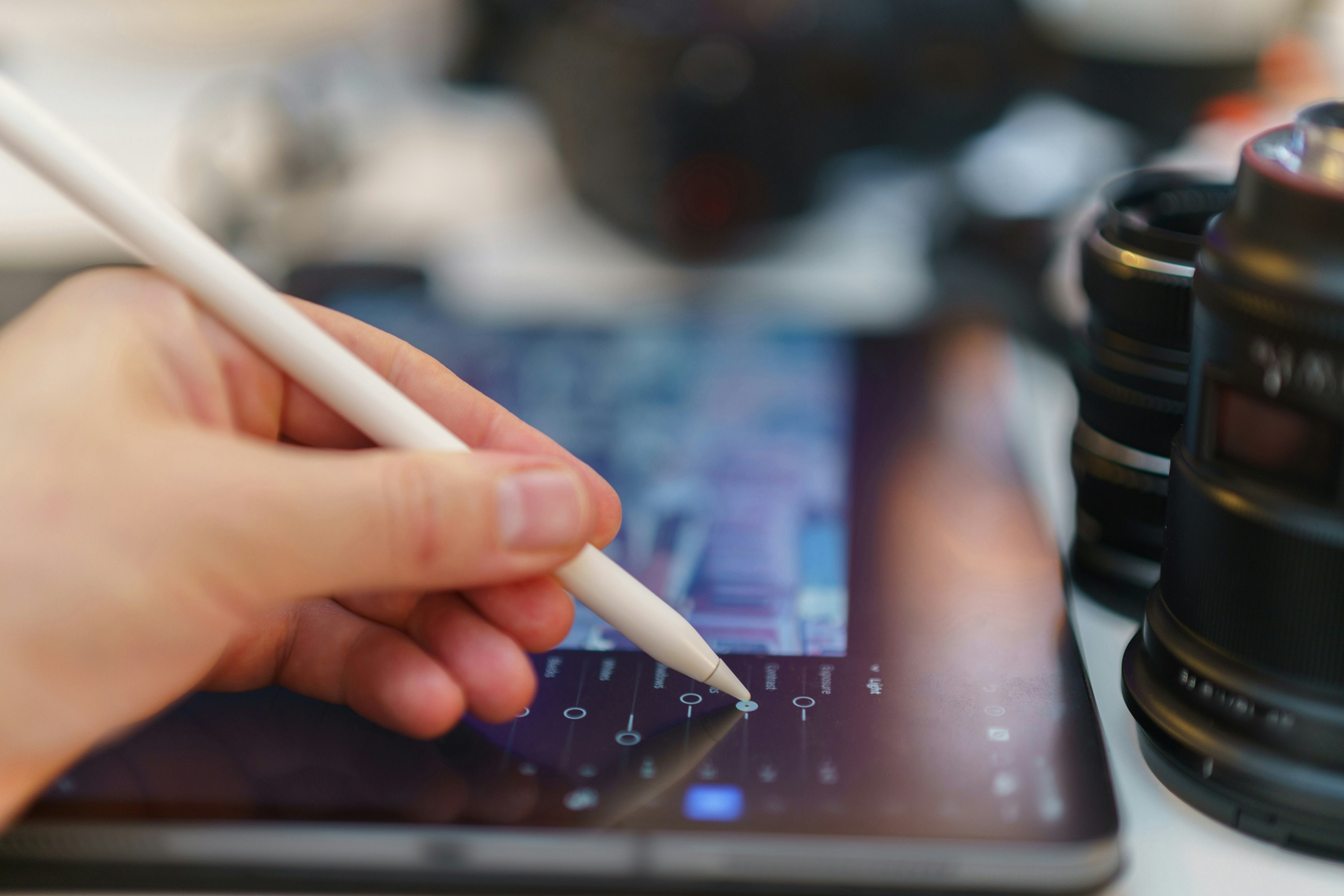 A person holding a pen and writing on a tablet