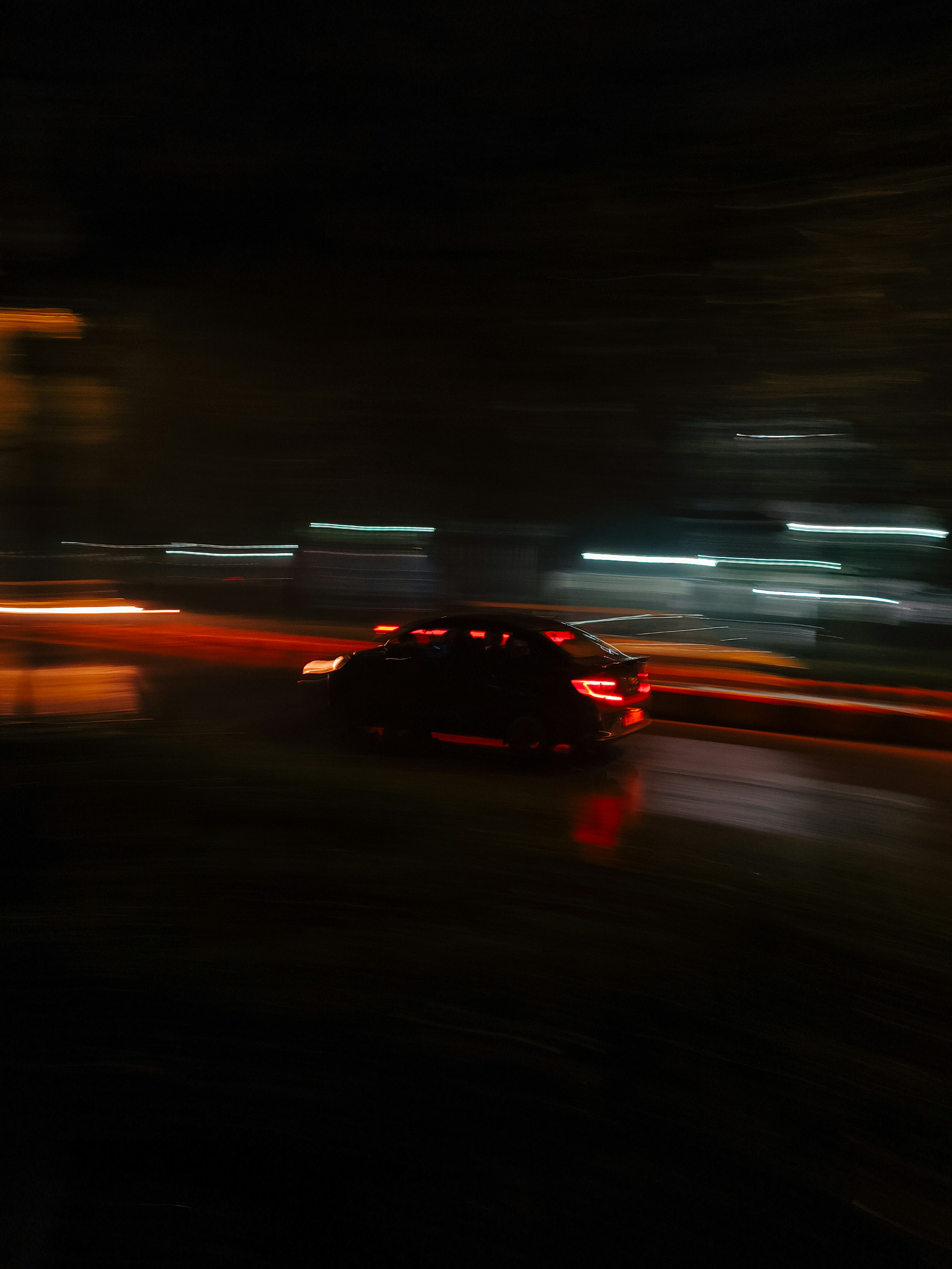 Car driving on a wet road at night