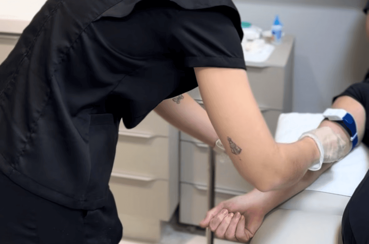 person sitting while using laptop computer and green stethoscope near