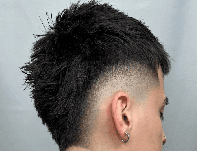 Man with textured crop haircut, high skin fade, and tapered neckline.