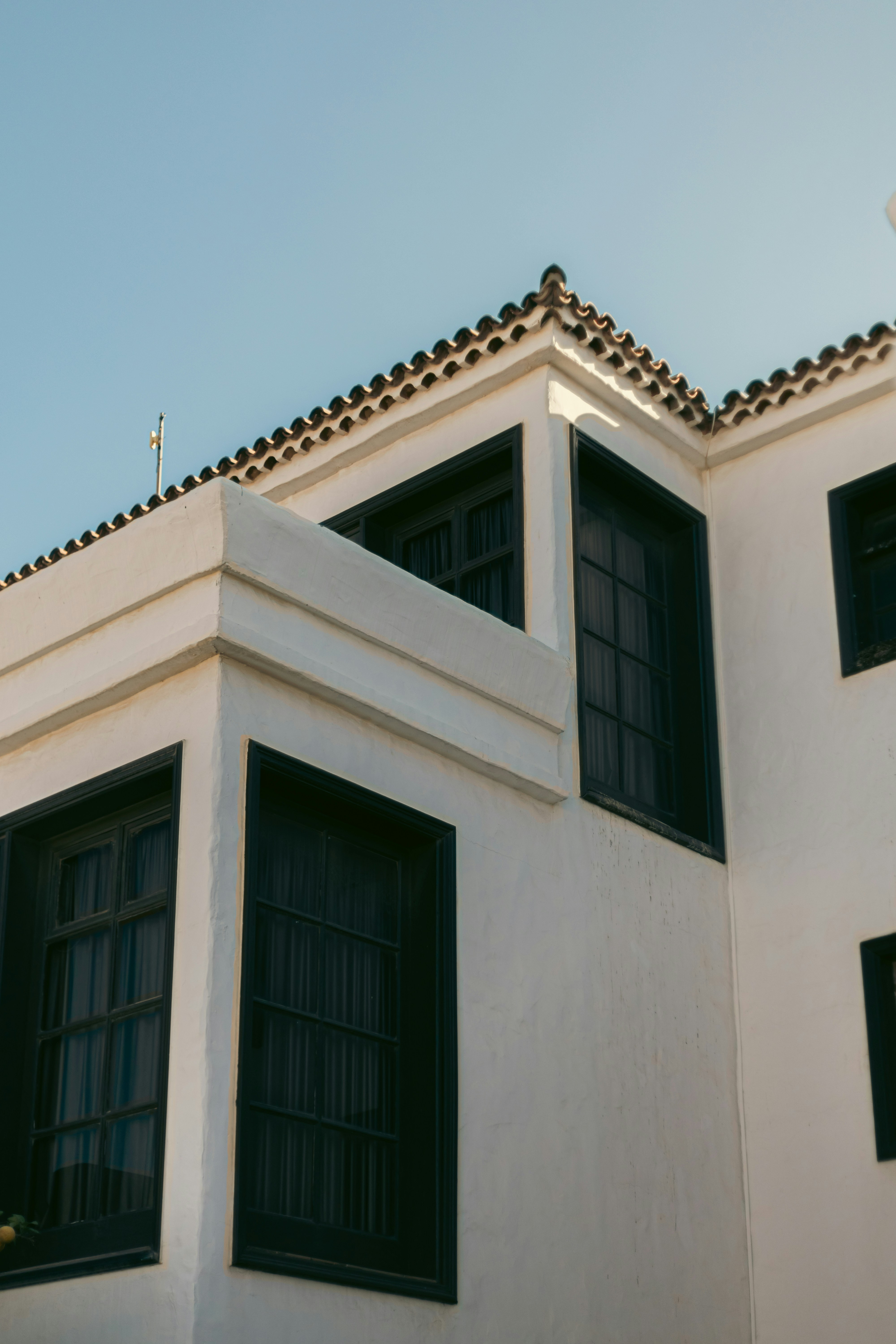 A white building with black windows and a cross on top of it