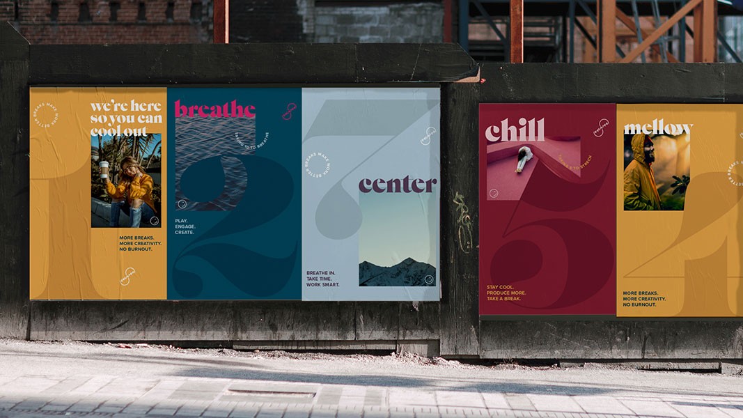Four posters are displayed on a dark wall, each with a distinct color scheme and design. The leftmost poster is yellow and features a woman in a yellow jacket seated outdoors. The text reads “we’re here so you can cool out.” The second poster is teal with a wave-like design and the text "breathe" and "PLAY, ENGAGE, CREATE." The third poster is white with a light blue gradient and the text "center" and "BREATHE IN. TAKE TIME. WORK SMART." The fourth poster is maroon with a stylized figure and the text "chill" and "MELLOW." The posters are mounted on a concrete wall with a metal railing visible behind them.