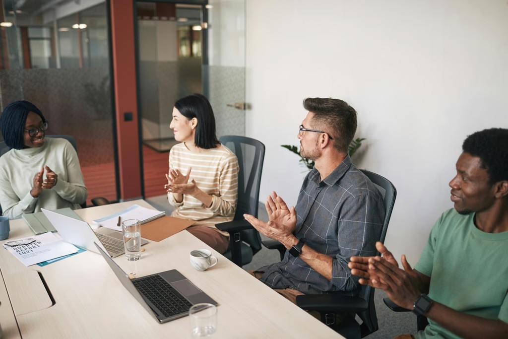 Team members discussing work during a conference room meeting