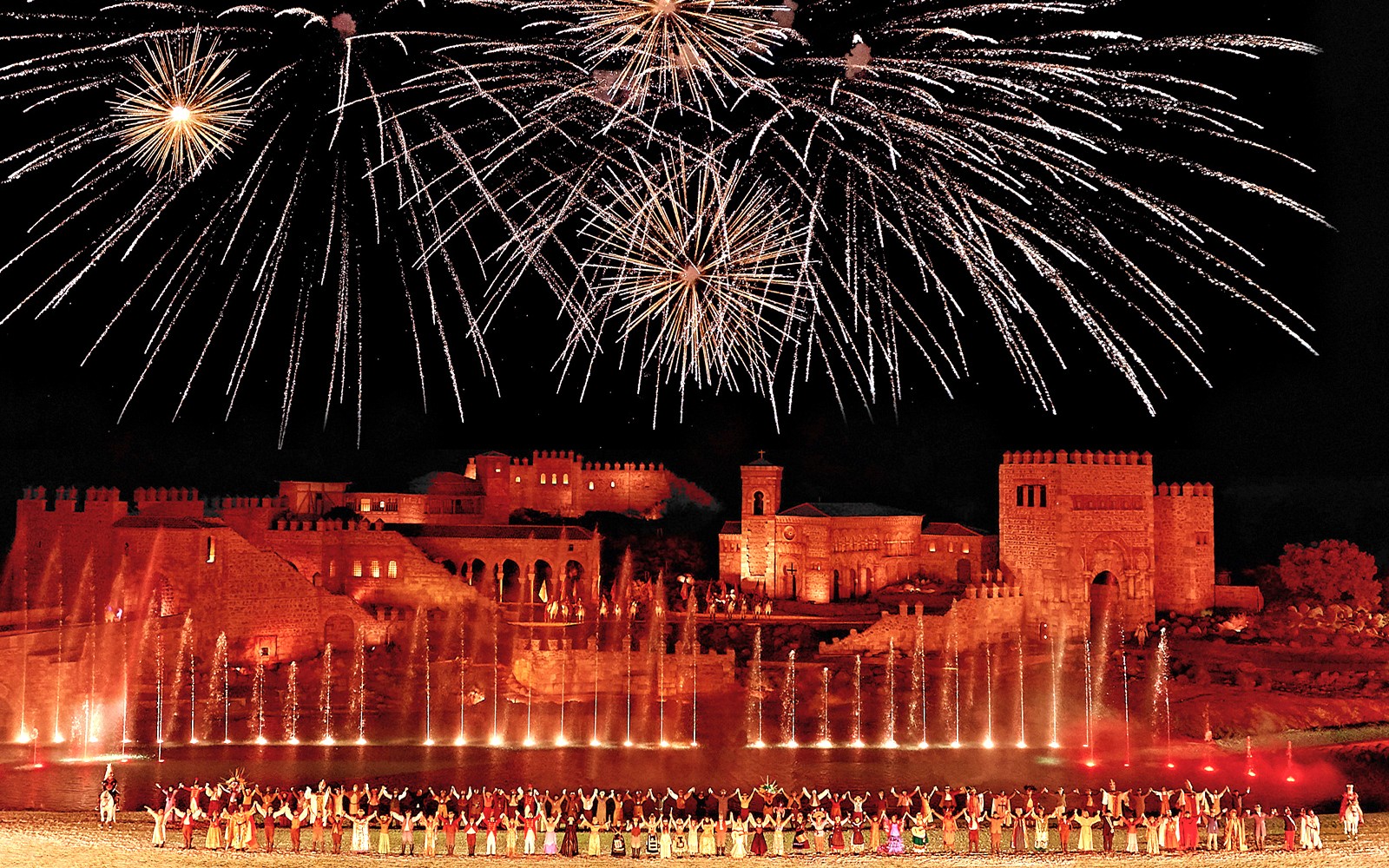 Espectáculo nocturno en Toledo con artistas en trajes históricos en el escenario.