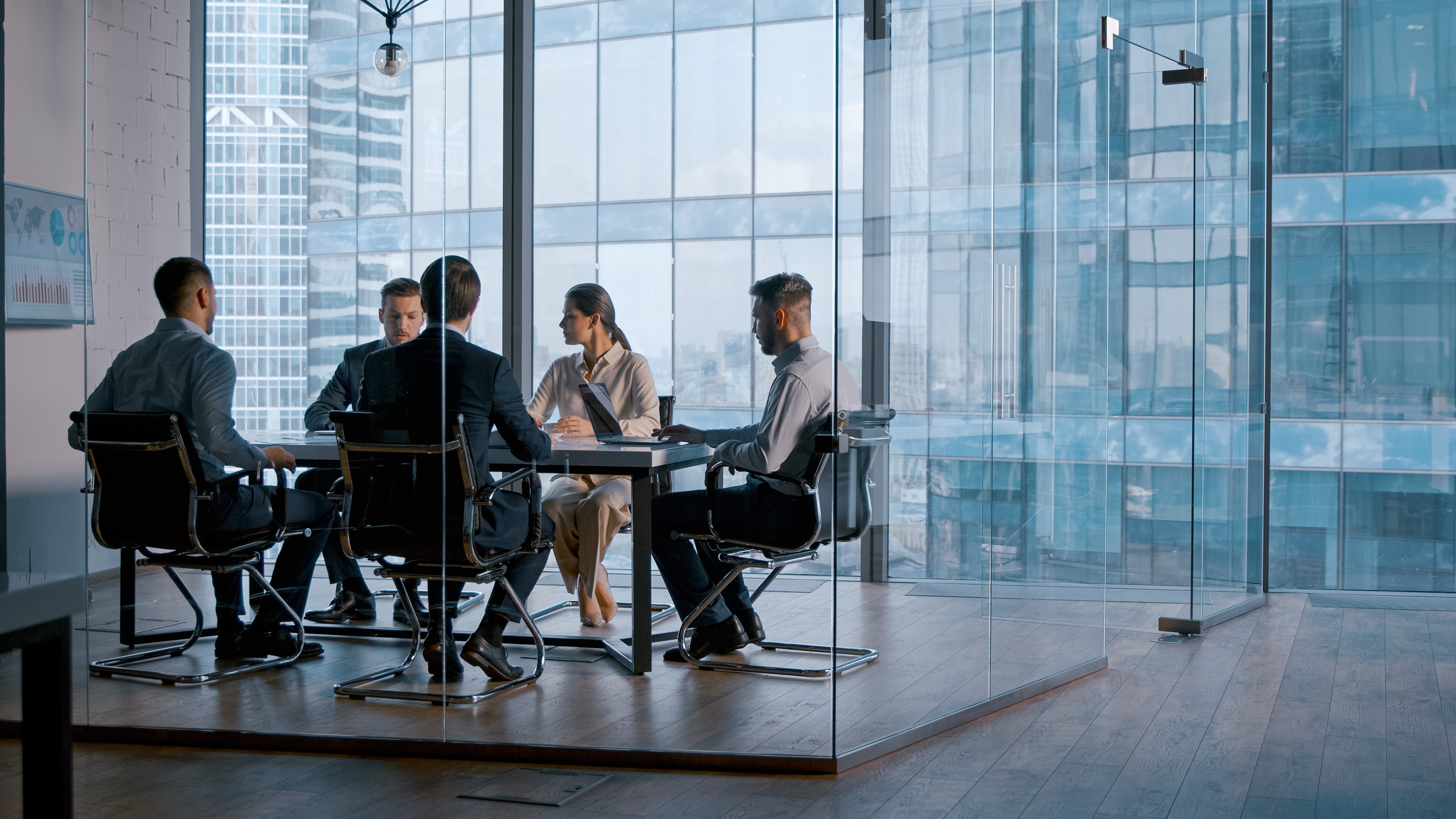 A management meeting in a glass cubicle in a company office