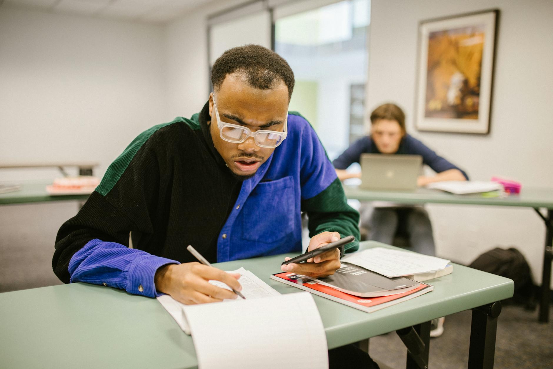 A high school student completes a chemistry lab experiment while referring to a rubric on a tablet.