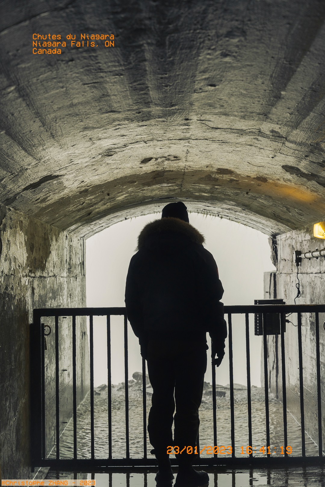 Silhouette d'un homme dans un tunnel, observant les chutes du Niagara.