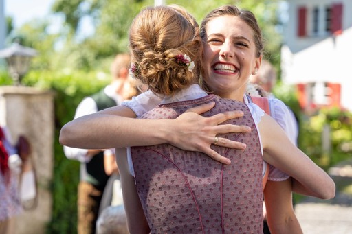 Braut wird herzlich umarmt und lacht nach der Trauung während Hochzeit