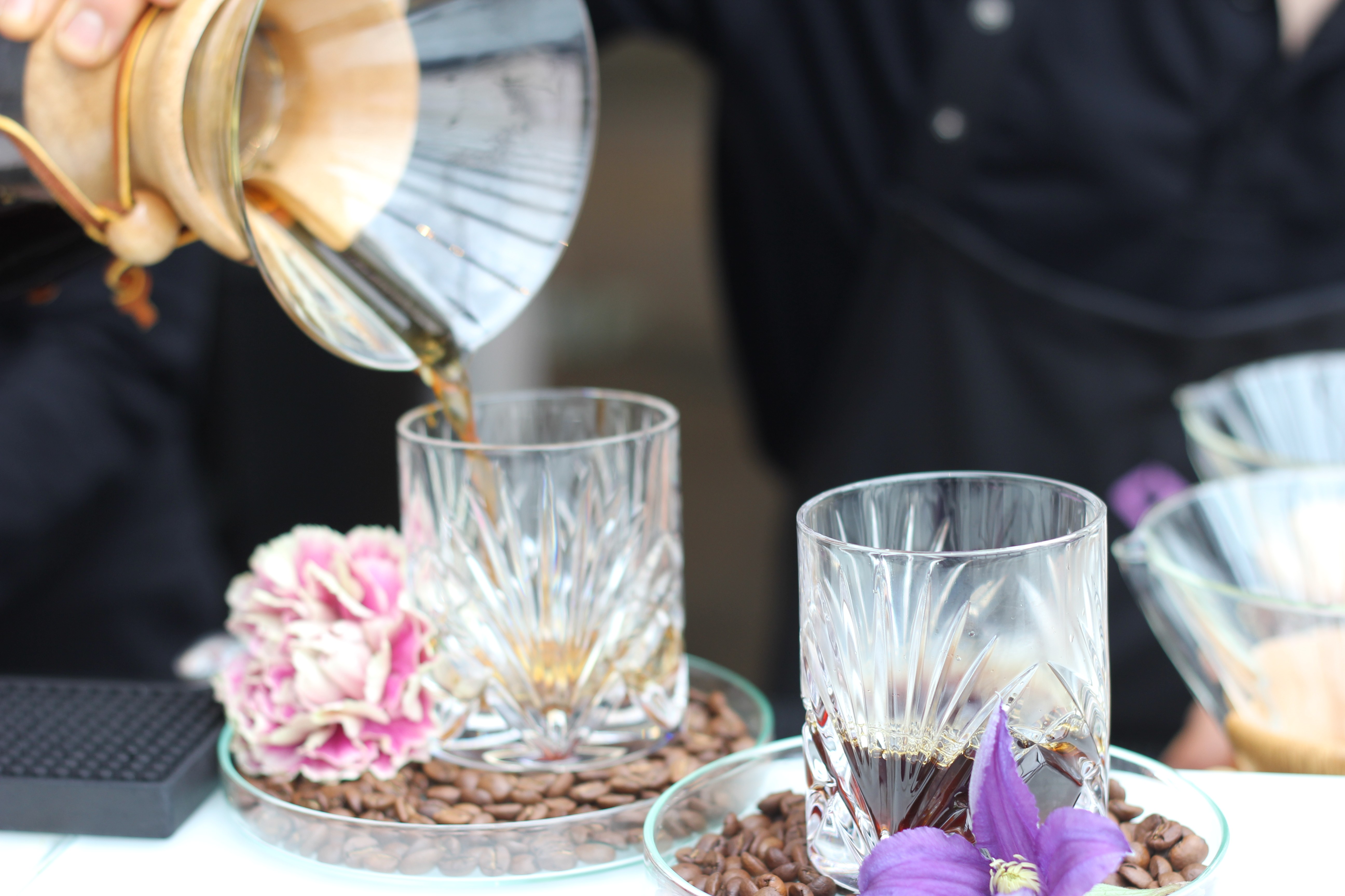 Tee wird in Kristallgläser mit Blumendekoration eingeschenkt