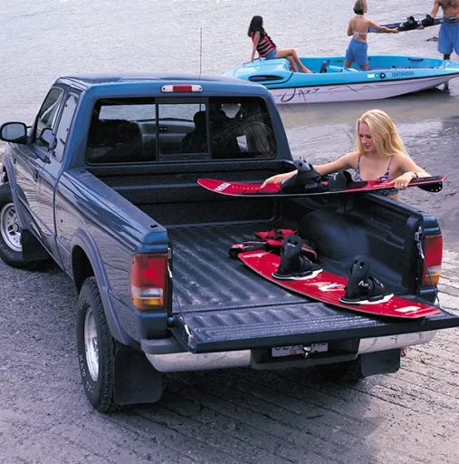 Woman loading surfboards into a rubberised load bin